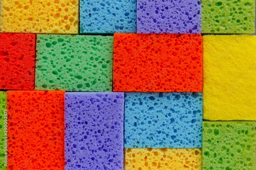 Cleaning day concept, colorful sponges over gray concrete background