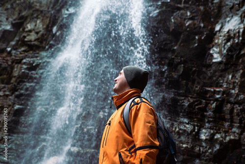 man hiking concept looking at waterfall in dip forest