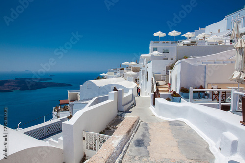 Tourists walking around the beautiful alleys of Fira City at the Santorini Island in a beautiful early spring day