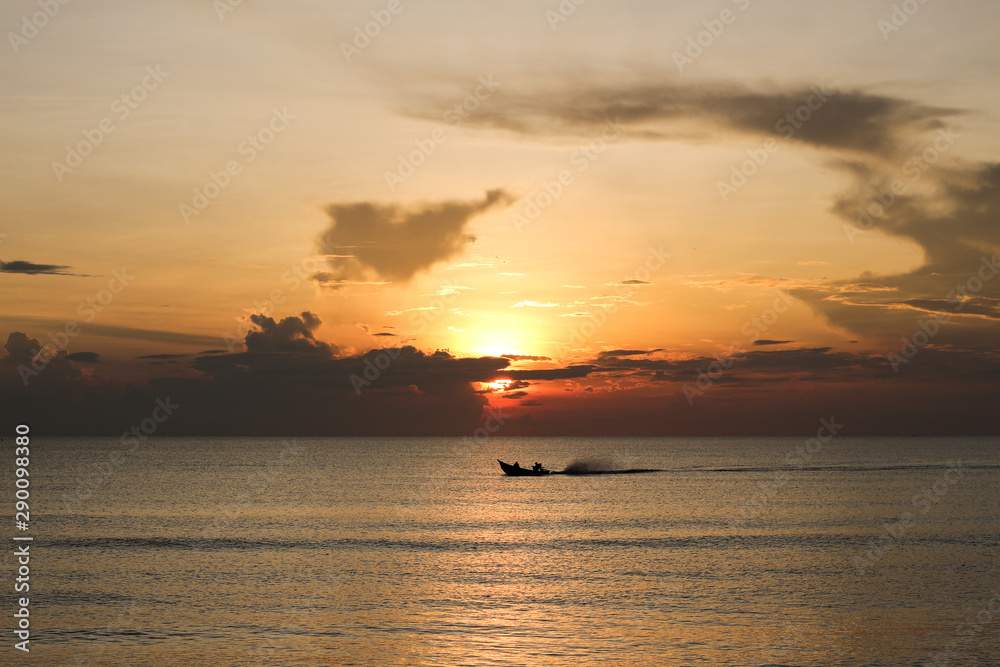 Fisherman on the boat over sunset time, beautiful seascape and ship silhouette in ocean over sunlight