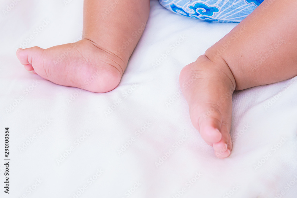 asian baby's feet are sleeping on a white bed sheet with copy space asian baby's feet are sleeping on a white bed sheet with copy space