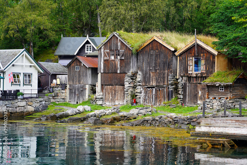 Geiranger ( Norwegen) Fischerhäuser am Norwegischen Geiranger Fjord, Fischerhäuser am Fjord , Beauty of Norway mit Hotz Haus am Wasser, Fluss, See in der Landschaft, Dorf am Wald mit Bäumen 