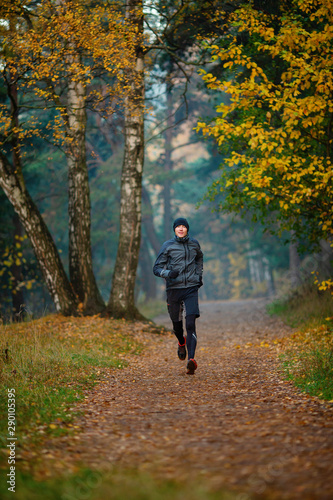 Photo of running athlete in autumn park