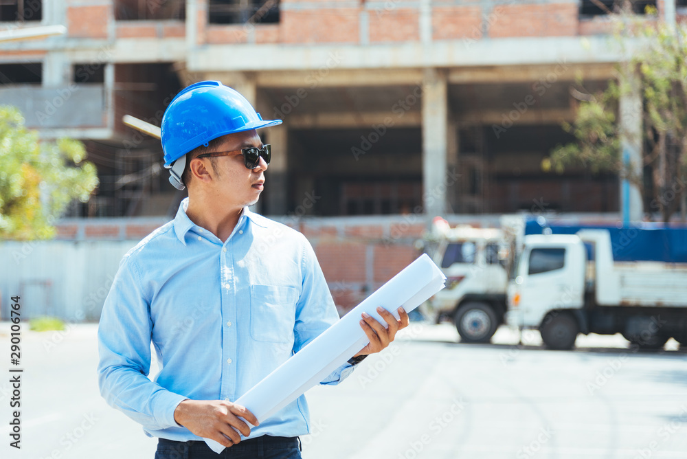 Asian man architect wearing blue safety helmet checking working progress at construction site. Asian man architect wearing blue safety helmet checking working progress at construction site.