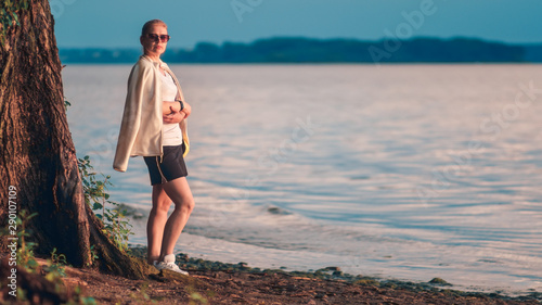 A woman is resting after a jog on the lake.