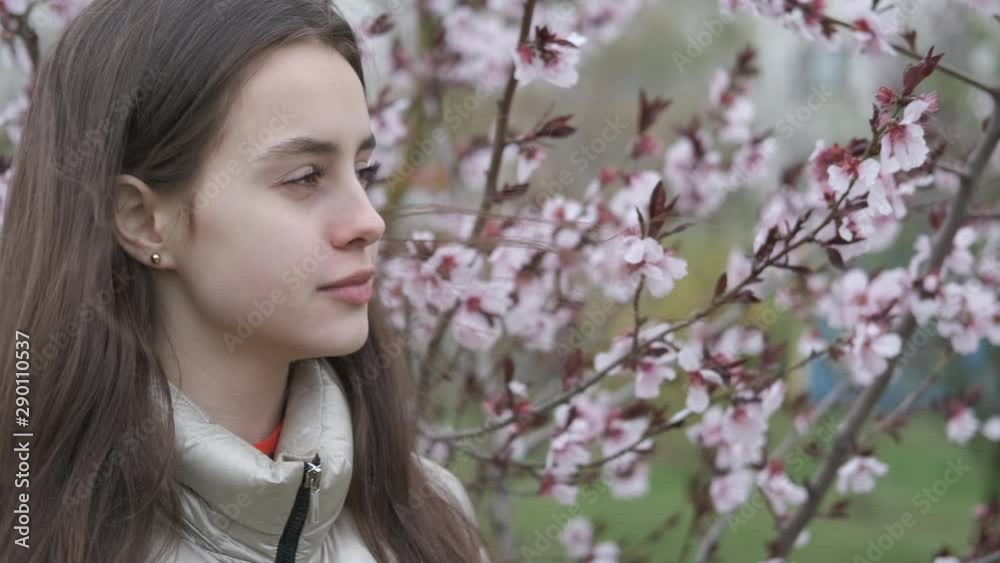 Pensive spring girl. Beautiful young girl in a spring blooming park. Pensive spring girl. Beautiful young girl in a spring blooming park.