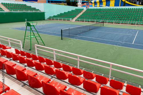 Sport stadium with several rows of spectator seating and tennis court at sport stadium or performance venue.
