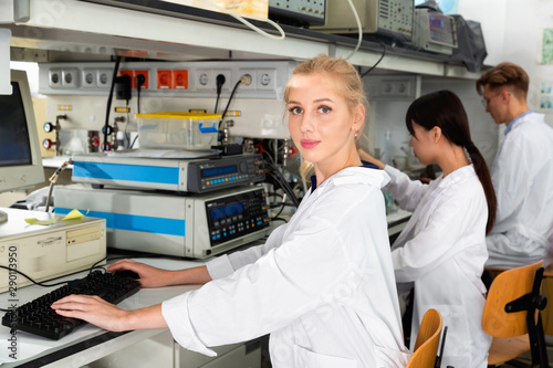 Portrait of young female scientist near laboratory equipment at biochemical lab
