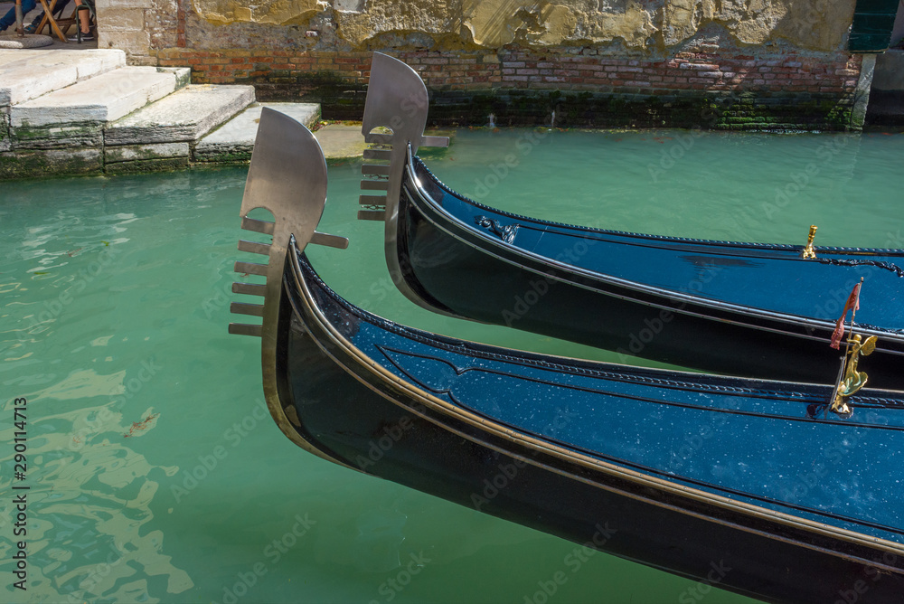 Venice, Italy. Close up of a two gondolas and the blue water of a Venetian canal, in a beautiful sunny day.