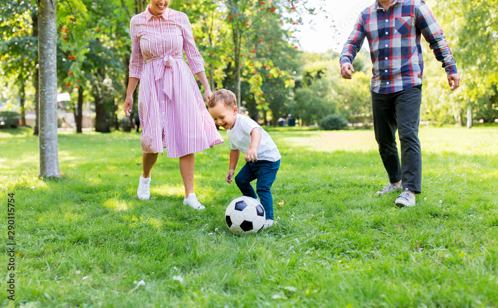 family, leisure and people concept - happy mother, father and little son with ball playing soccer at summer park family, leisure and people concept - happy mother, father and little son with ball playing soccer at summer park