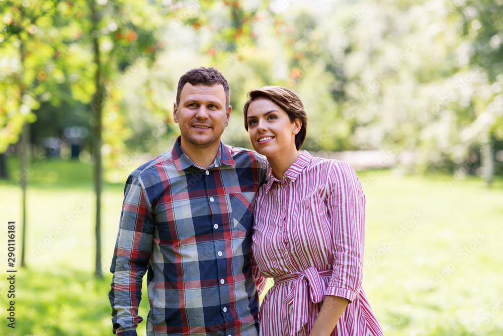 people and relationships concept - happy couple in summer park people and relationships concept - happy couple in summer park