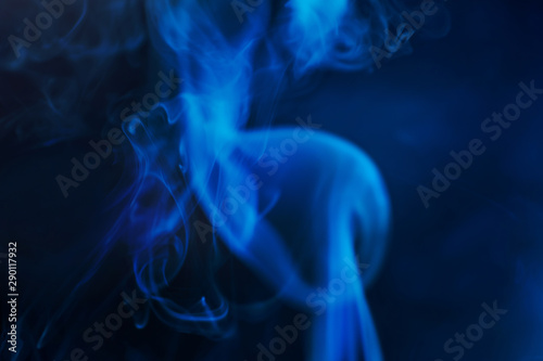 Smoke on a dark background in a mistery dark blue light. Minimalistic background concept. Copyspace.