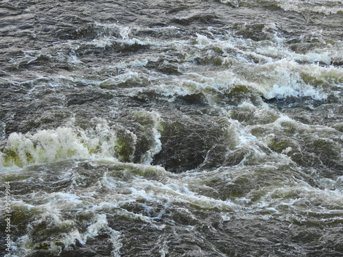 Rough churning water with whirlpool and white foam crests