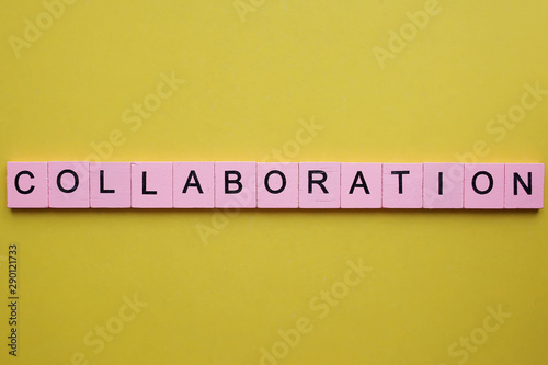 Collaboration word wooden cubes on an yellow background.