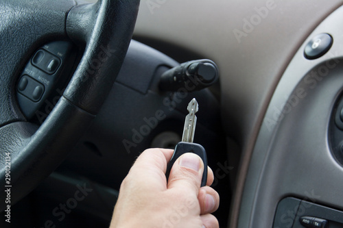 the man holds the key in his hand next to the ignition of the car and wants to start the car © Vlyaks