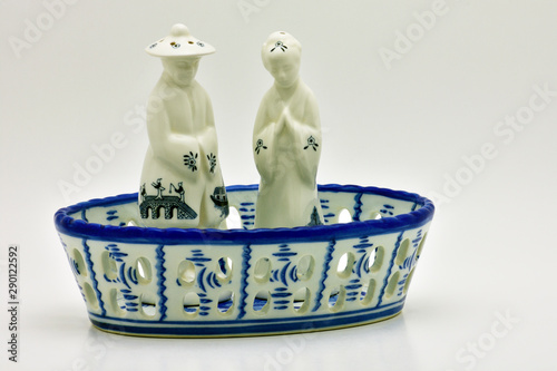 porcelain chinese salt and pepper shakers in a porcelain basket