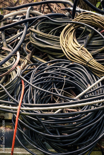 An abstract background of old salvaged used dirty wires and cables in coils and tangled mess, close-up