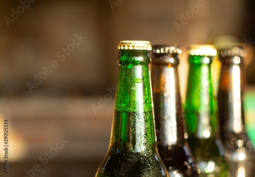 top part of green and brown beer bottles closeup