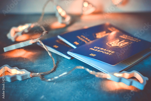 A trip to the winter New Year Christmas holidays with the whole family concept with ukrainian internetional biometric passports and christmas garland. photo