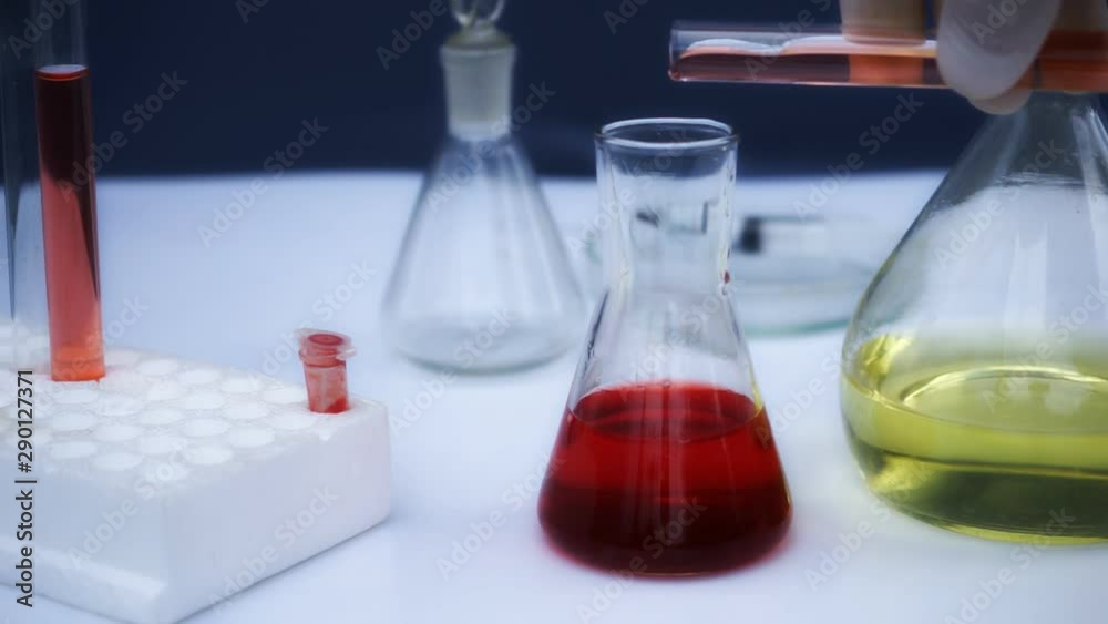 Scientist mixed color liquid in glass test tubes. Close up. Scientist mixed color liquid in glass test tubes. Close up.