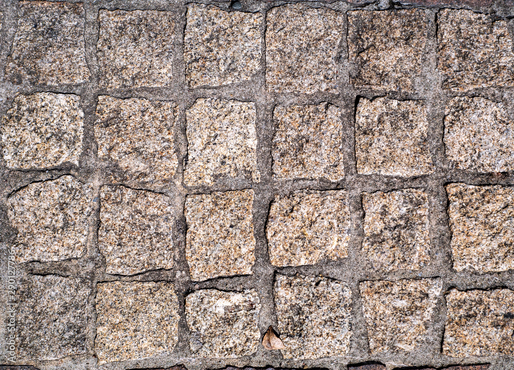 Fototapeta premium The pavement is paved with old medieval cobblestones in ordered rows.