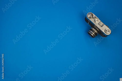 old vintage camera isolated on blue background, top view.