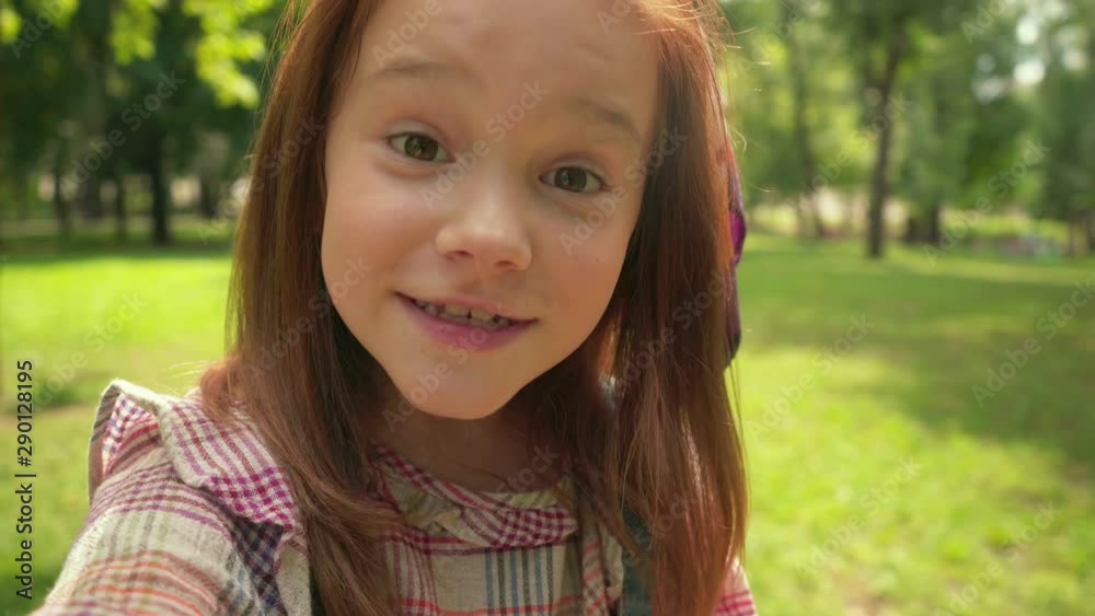 cute redhead child talking at camera and waving hand cute redhead child talking at camera and waving hand