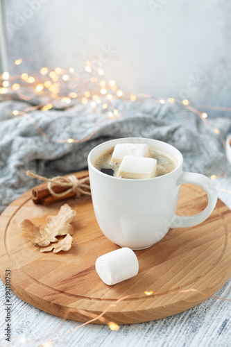 Mug with coffee and marshmallow  sweater  cinnamon  decorated with led lights. Autumn mood. Cozy autumn composition. Hygge concept Soft focus - Image