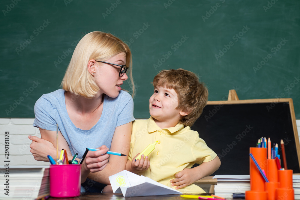 Back to school. School children. Female teacher and schoolboy in class at school. Great study achievement. Happy school kids. Back to school. School children. Female teacher and schoolboy in class at school. Great study achievement. Happy school kids.