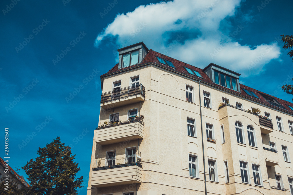 orange apartment house with fluffy clouds