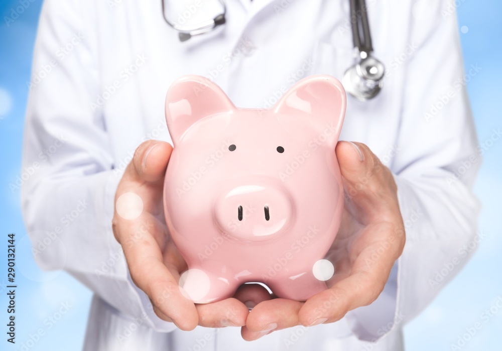 Doctor with Stethoscope Holding Piggy Bank close up
