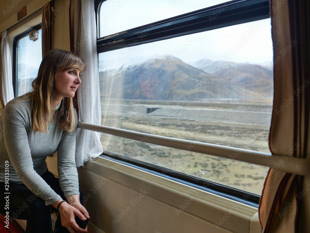 CLOSE UP Young woman rides along Trans-Himalayan Railway and observes landscape.