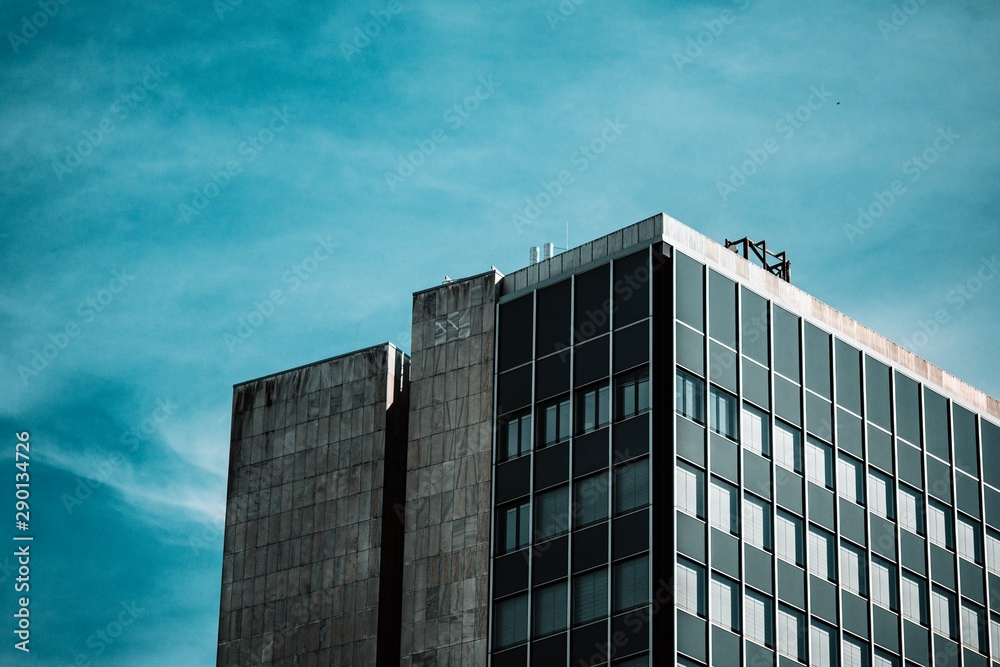 modern building with blue sky and clouds reflected in windows modern building with blue sky and clouds reflected in windows