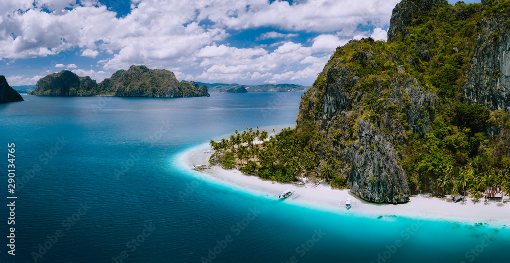 El Nido, Palawan, Philippines. Aerial drone shot of Ipil beach located on Pinagbuyutan Island. Amazing white sand, coconut palm trees and turquoise blue ocean water