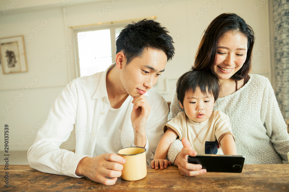 Parents and child are looking in mobile phone Parents and child are looking in mobile phone