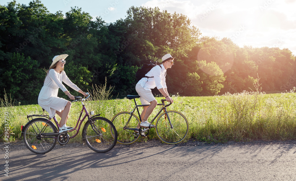 Obraz premium Cheerful girl and her enthusiastic boyfriend enjoying their rural bike trip
