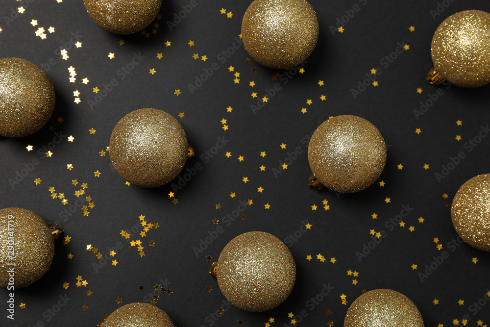 Christmas balls and glitter on black background. Happy new year