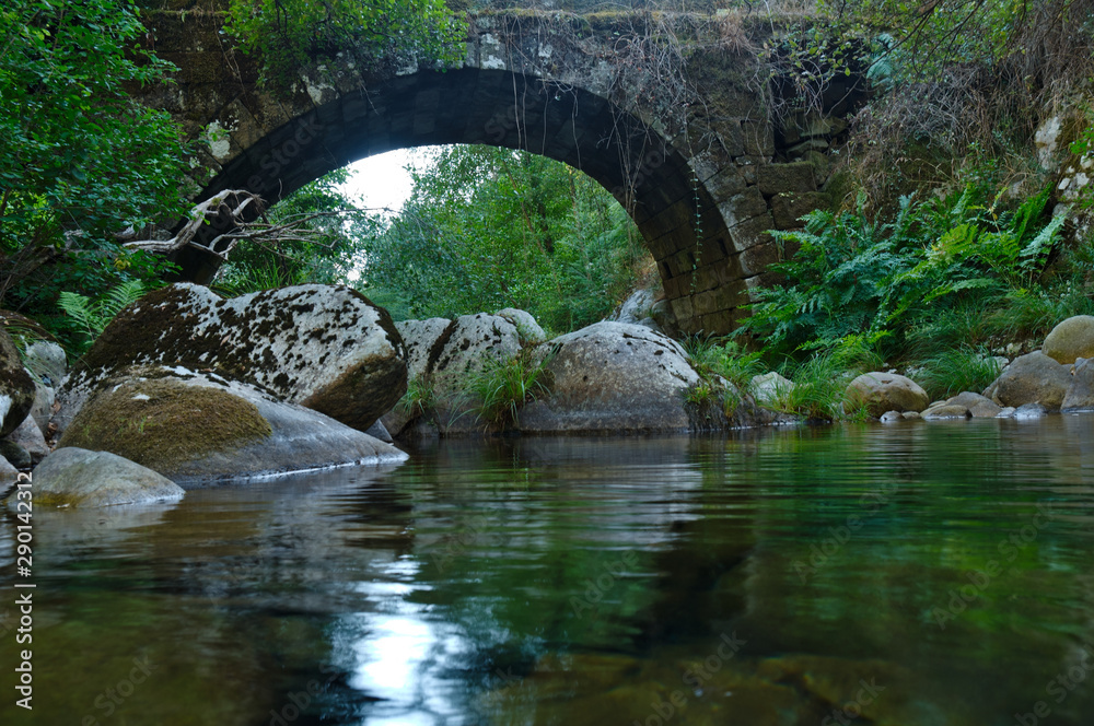 Antique arched stone bridge over Gralheira river in Carvalhais, Sao Pedro do Sul, Portugal