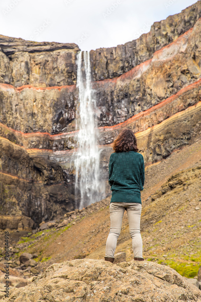 Hengifoss, Iceland »; August 2017: A young woman with a green jersey under the Hengifoss waterfall