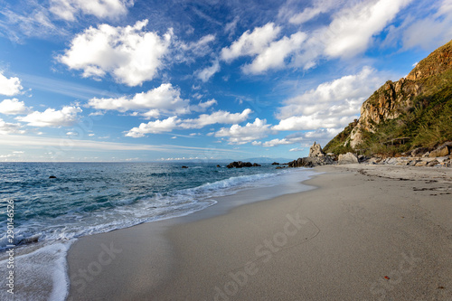 Beautiful Italian beach Michelino in Calabria, Italy - Beach sand at Mediterranean sea and blue sky with soft white clouds