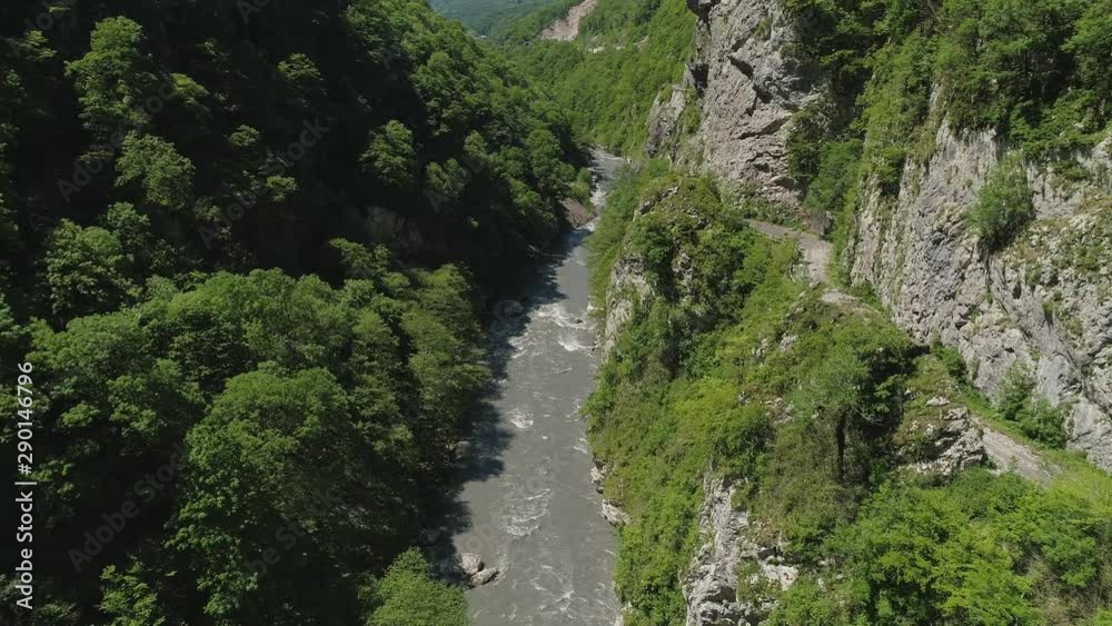 Aerial view fly above dirty mountain river in valley Aerial view fly above dirty mountain river in valley