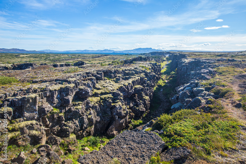 Walls that separate the tectonic plates in Þingvallavatn and the background landscape. Iceland