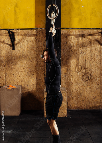 Man working out with gymnastic rings at the crossfit gym © qunica.com