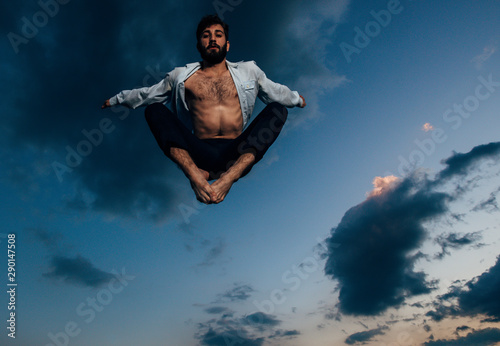 Awesome dancer is jumping very high in the sunset sky