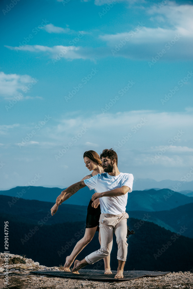 Full length of an elegant couple dancing together over blue sky