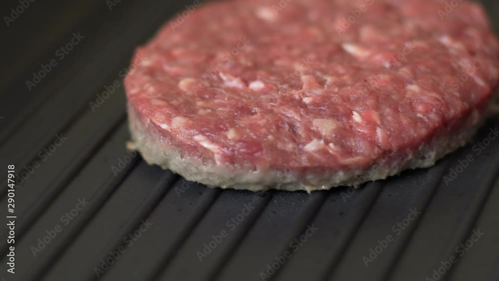 Closeup amazing slow motion of raw organic burger meat for hamburger cooked on hot grill. Macro shot. Closeup amazing slow motion of raw organic burger meat for hamburger cooked on hot grill. Macro shot.
