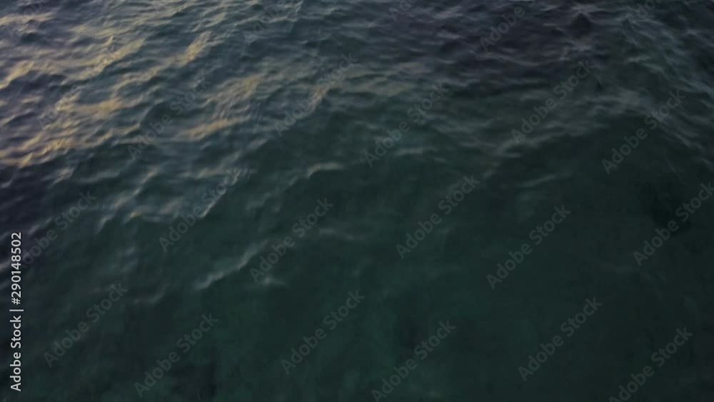 A low flying reveal shot over the sea tilting up to show a boat and the horizon. A low flying reveal shot over the sea tilting up to show a boat and the horizon.