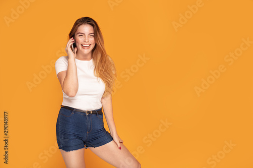 Laughing happy girl talking by mobile phone.