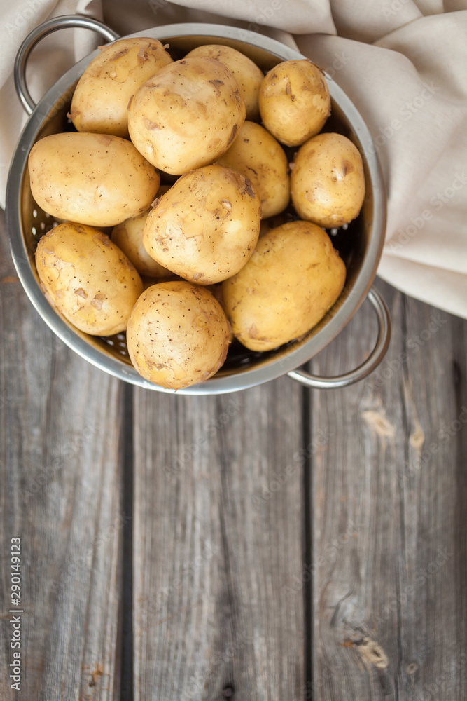 Raw potato. Fresh new potatoes on wooden background. Top view Raw potato. Fresh new potatoes on wooden background. Top view