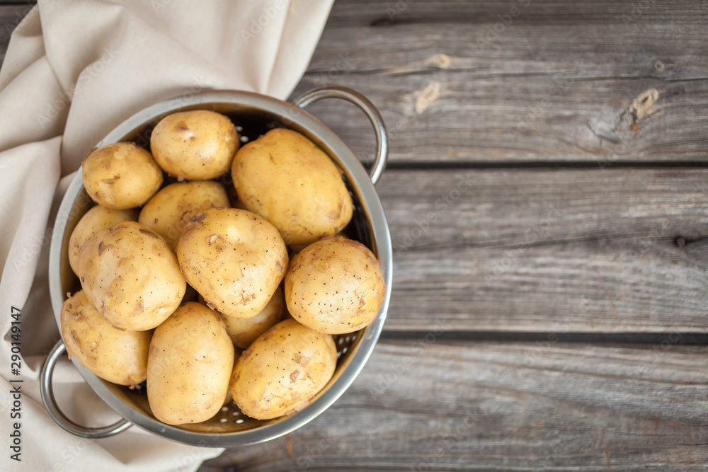 Raw potato. Fresh new potatoes on wooden background. Top view Raw potato. Fresh new potatoes on wooden background. Top view
